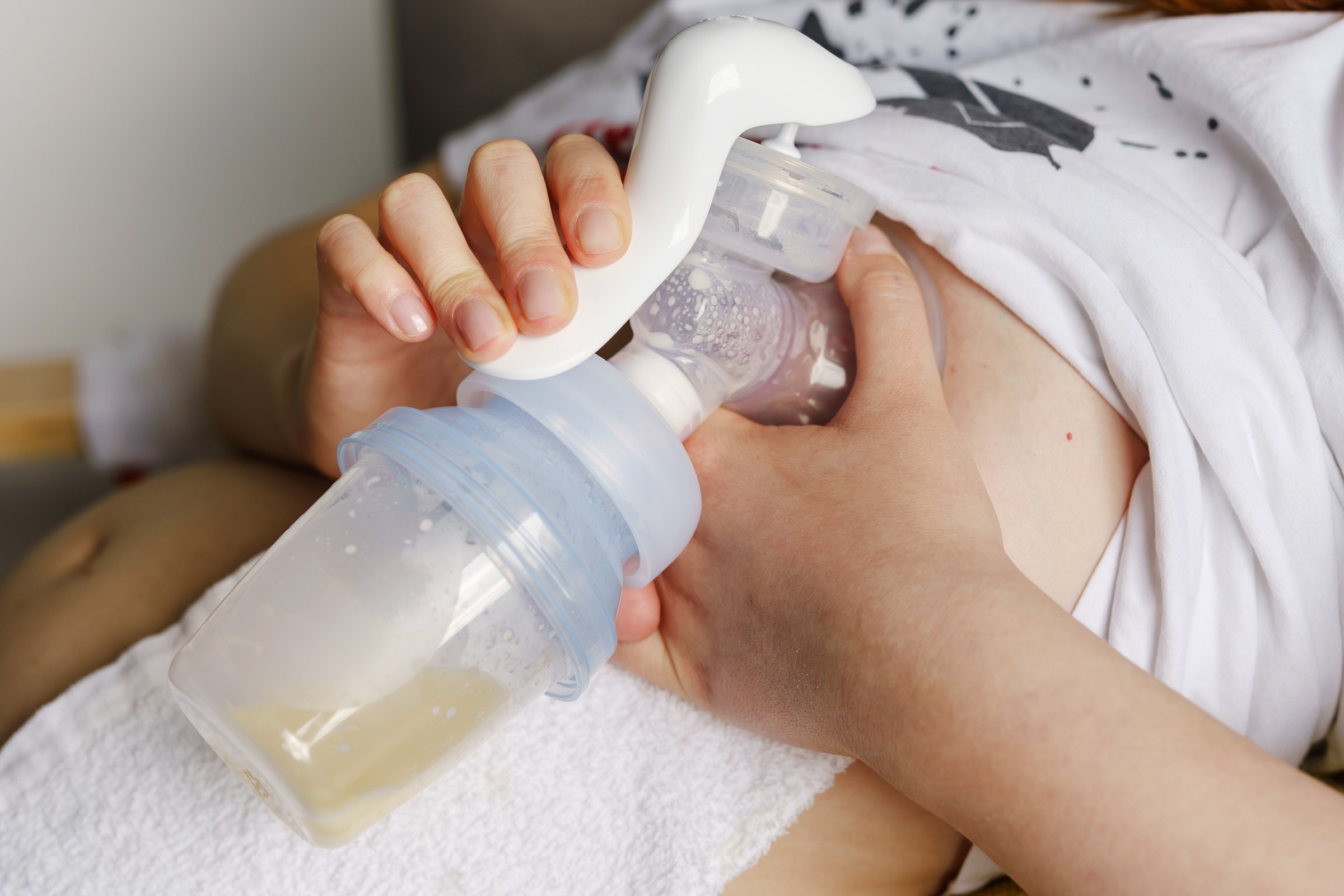Tire-lait posé à côté d'un biberon de lait maternel fraîchement tiré